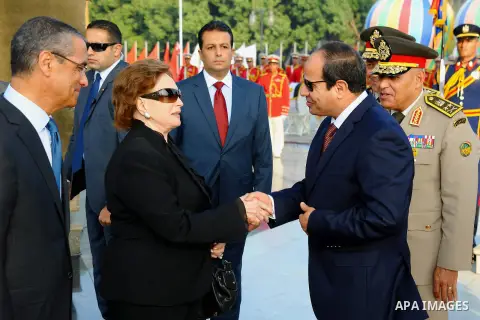 A handout picture released by the Egyptian Presidency shows Egyptian President Abdul Fattah al-Sisi (2ndR) shake hands with widow of former Egyptian President Sadat's after visiting his grave during a ceremony at the mem...