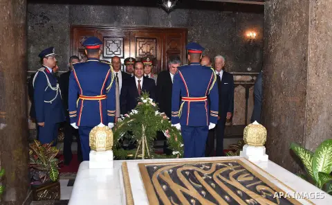 A handout picture released by the Egyptian Presidency shows Egyptian President Abdul Fattah al-Sisi (C) paying his respects in front of the grave of former Egyptian President Gamal Abdel Nasser during a ceremony at the m...