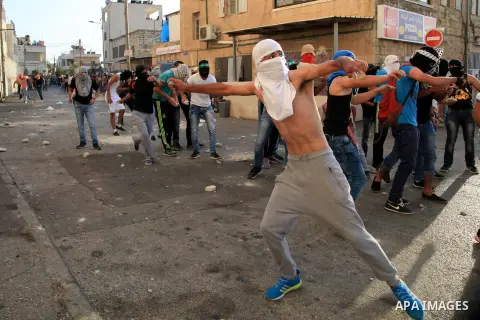 Palestinian protesters throw stones at Israeli police during clashes in Shuafat, an Arab suburb of Jerusalem October 5, 2015. A Palestinian teenager was killed on Monday in a clash with Israeli soldiers near the West Ban...