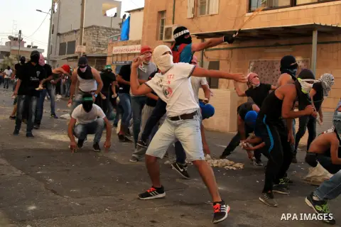 Palestinian protesters throw stones at Israeli police during clashes in Shuafat, an Arab suburb of Jerusalem October 5, 2015. A Palestinian teenager was killed on Monday in a clash with Israeli soldiers near the West Ban...