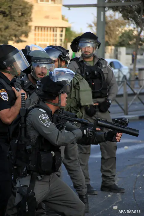 An Israeli policeman fires tear gas at Palestinian protester during clashes in Shuafat, an Arab suburb of Jerusalem October 5, 2015. A Palestinian teenager was killed on Monday in a clash with Israeli soldiers near the W...