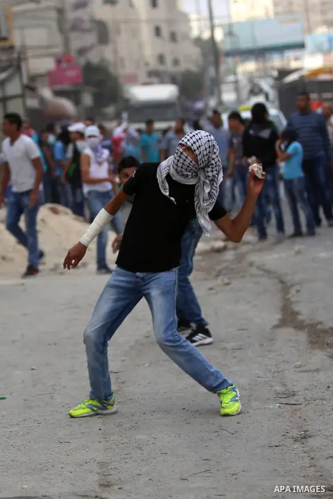 Palestinian protesters throw stones towards Israeli security forces during clashes at Qalandia checkpoint near occupied West Bank city of Ramallah, October 6, 2015. Clashes erupted the day before in the West Bank and eas...