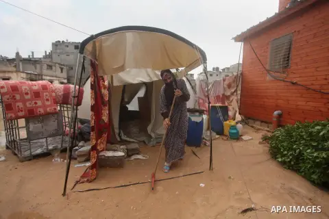 A Palestinian woman, whose house was destroyed by what witnesses said was Israeli shelling during a 50-day war in the summer of 2014, removes rainwater that flooded her makeshift shelter in Khan Younis in the southern Ga...
