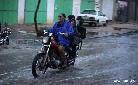 A Palestinian man rides a motorcycle in a flooded street during a rainy day in Khan Younis in the southern Gaza Strip October 7, 2015. Photo by Ashraf Amra