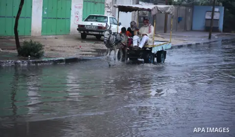 A Palestinian man rides a donkey cart in a flooded street during a rainy day in Khan Younis in the southern Gaza Strip October 7, 2015. Photo by Ashraf Amra