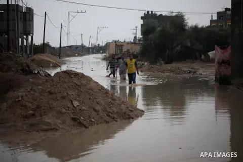 Palestinians walk in a flooded street during a rainy day in Khan Younis in the southern Gaza Strip October 7, 2015. Photo by Ashraf Amra