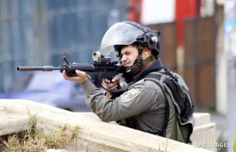 An Israeli soldier aims at Palestinian protesters during clashes in the village of Beit Ummar near the southern West Bank city of Hebron on October 8, 2015. There have been at least eight stabbing attacks since the begin...