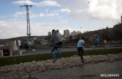 Palestinian protesters throw stones at Israeli security forces during clashes in Beit El, near the West Bank city of Ramallah, on October 8, 2015. New violence rocked Israel and the Israeli occupied West Bank, including...