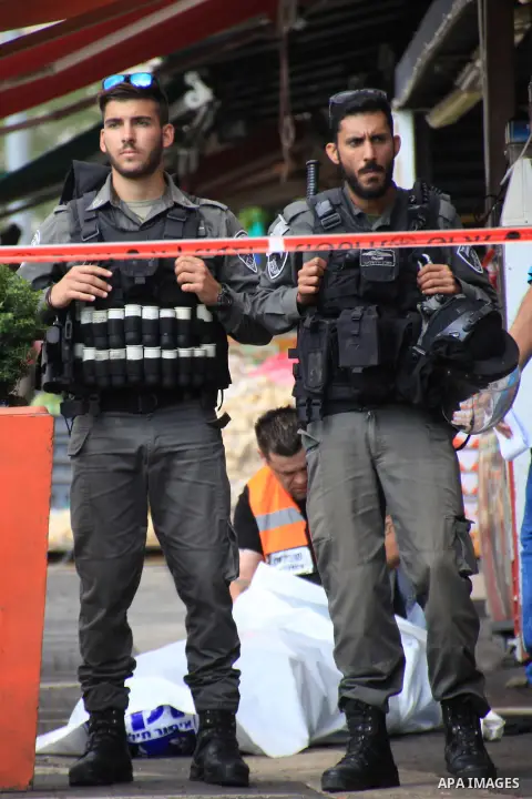 Israeli police secure the area as they stand next to the body of a dead Palestinian assailant at the spot where he stabbed two Israeli Jews before was shot dead outside Jerusalem's Old City October 10, 2015. Israeli forc...