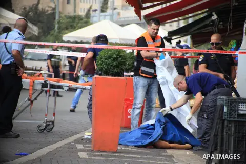 Israeli police secure the area as they stand next to the body of a dead Palestinian assailant at the spot where he stabbed two Israeli Jews before was shot dead outside Jerusalem's Old City October 10, 2015. Israeli forc...