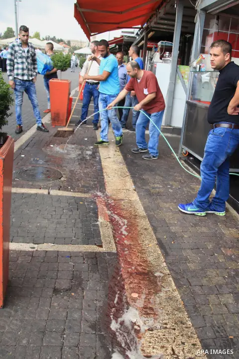 Palestinians clean the scene of a stabbing attack outside Jerusalem's Old City October 10, 2015. Israeli forces shot dead two Palestinian assailants in East Jerusalem on Saturday, one of whom had stabbed two Israelis, po...