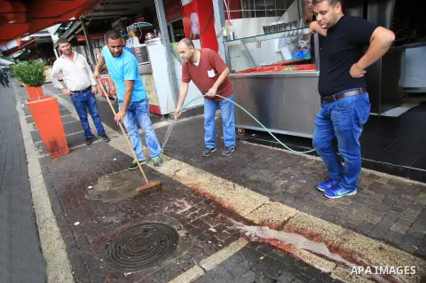 Palestinians clean the scene of a stabbing attack outside Jerusalem's Old City October 10, 2015. Israeli forces shot dead two Palestinian assailants in East Jerusalem on Saturday, one of whom had stabbed two Israelis, po...