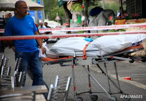 Israeli police secure the area as they stand next to the body of a dead Palestinian assailant at the spot where he stabbed two Israeli Jews before was shot dead outside Jerusalem's Old City October 10, 2015. Israeli forc...