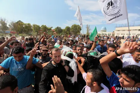 Palestinian militants of the Ezzedine al-Qassam Brigades, Hamas' armed wing, carry the body of Palestinian protester 22-year-old Jihad al-Obeid, who died in clashes with Israeli security forces near the border, during hi...