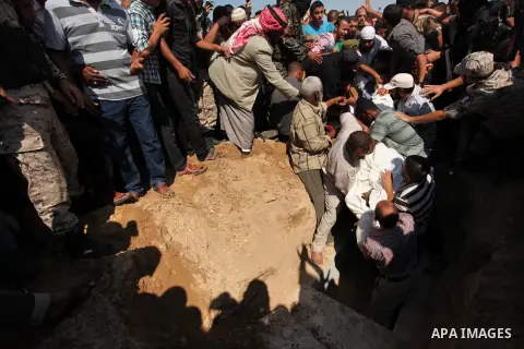 Palestinian militants of the Ezzedine al-Qassam Brigades, Hamas' armed wing, carry the body of Palestinian protester 22-year-old Jihad al-Obeid, who died in clashes with Israeli security forces near the border, during hi...