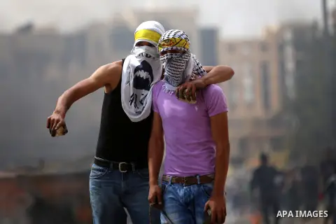 Palestinian protesters hurl stones during clashes with Israeli security forces in Beit El on the outskirts of the West Bank city of Ramallah, on October 10, 2015. Fifteen Palestinians have been killed by Israeli forces a...