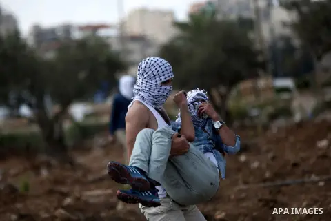 A Palestinian protester is evacuated by comrades after being injured during clashes with Israeli security forces in Beit El on the outskirts of the West Bank city of Ramallah, on October 10, 2015. Fifteen Palestinians ha...