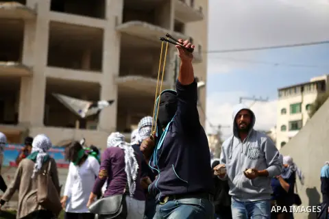 Palestinian protesters hurl stones during clashes with Israeli security forces in Beit El on the outskirts of the West Bank city of Ramallah, on October 10, 2015. Fifteen Palestinians have been killed by Israeli forces a...