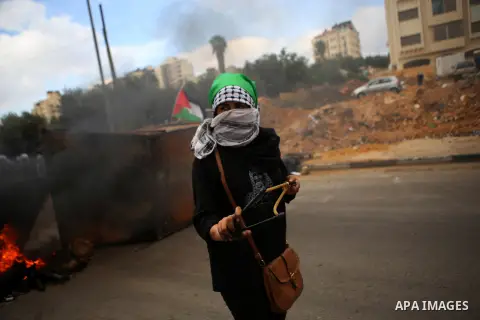 A female Palestinian protester hurl stones during clashes with Israeli security forces in Beit El on the outskirts of the West Bank city of Ramallah, on October 10, 2015. Fifteen Palestinians have been killed by Israeli...