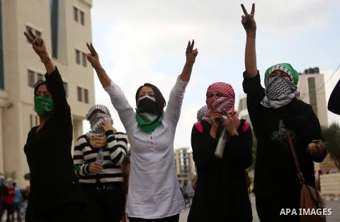 Palestinian girls flashe victory sign during clashes with Israeli security forces in Beit El on the outskirts of the West Bank city of Ramallah, on October 10, 2015. Fifteen Palestinians have been killed by Israeli force...