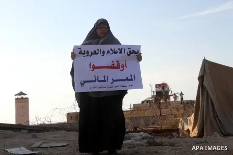 A Palestinian women holds placards during a protest to demand the Egyptian goverment stopping pump large amounts of sea water along the border between Egypt and Gaza, southern Gaza Strip on Oct. 10, 2015. Last month, the...