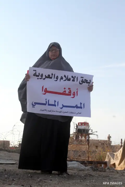 A Palestinian women holds placards during a protest to demand the Egyptian goverment stopping pump large amounts of sea water along the border between Egypt and Gaza, southern Gaza Strip on Oct. 10, 2015. Last month, the...