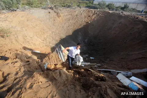 Palestinians inspect the damage after an Israeli retaliatory air strike demolished the house of a Palestinian family on October 11, 2015 in the Zeitun sector south of Gaza City. A pregnant Palestinian mother and her todd...