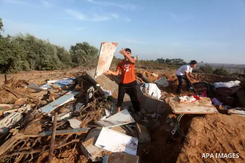 Palestinians inspect the damage after an Israeli retaliatory air strike demolished the house of a Palestinian family on October 11, 2015 in the Zeitun sector south of Gaza City. A pregnant Palestinian mother and her todd...
