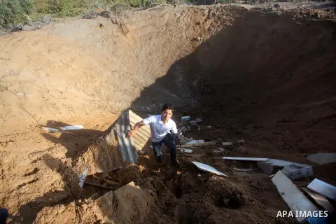 Palestinians inspect the damage after an Israeli retaliatory air strike demolished the house of a Palestinian family on October 11, 2015 in the Zeitun sector south of Gaza City. A pregnant Palestinian mother and her todd...