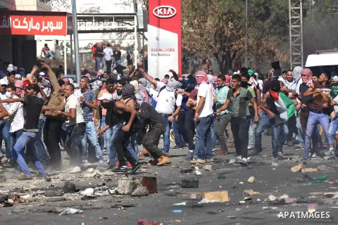 Palestinian protesters throw stones towards Israeli security forces during clashes at the Hawara checkpoint, south of the West Bank city of Nablus, on October 11, 2015. An Israeli air strike in Gaza killed a pregnant wom...