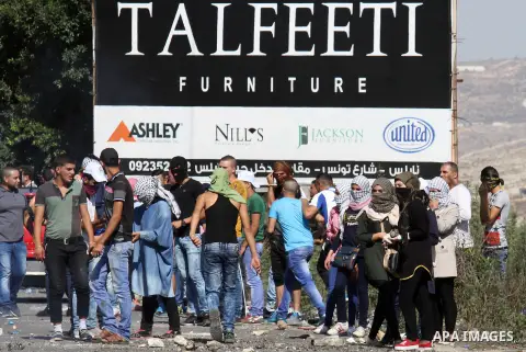 Palestinian protesters throw stones towards Israeli security forces during clashes at the Hawara checkpoint, south of the West Bank city of Nablus, on October 11, 2015. An Israeli air strike in Gaza killed a pregnant wom...