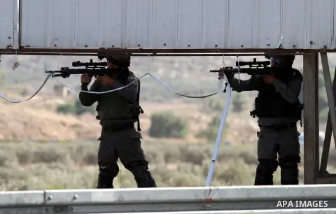 Israeli border guards keep position during clashes with Palestinian protestors at the Hawara checkpoint, south of the West Bank city of Nablus, on October 11, 2015. An Israeli air strike in Gaza killed a pregnant woman a...