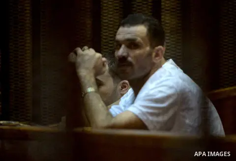 Egyptian defendants wait behind bars for the verdict in their retrial over a 2012 stadium riot in the canal city of Port Said at the police academy on the outskirts of the capital Cairo on Oct. 12, 2015. Seven defendants...