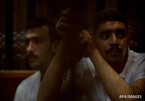 Egyptian defendants wait behind bars for the verdict in their retrial over a 2012 stadium riot in the canal city of Port Said at the police academy on the outskirts of the capital Cairo on Oct. 12, 2015. Seven defendants...