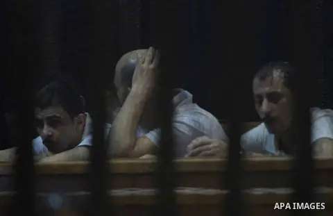 Egyptian defendants wait behind bars for the verdict in their retrial over a 2012 stadium riot in the canal city of Port Said at the police academy on the outskirts of the capital Cairo on Oct. 12, 2015. Seven defendants...