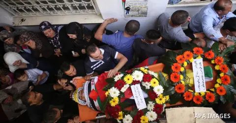 Mourners carry the body of 13-year-old Palestinian boy Ahmed Sharaka, who was killed by Israeli troops during clashes on Sunday after being hit in the head by a plastic-coated metal bullet, during his funeral in Jalazoun...