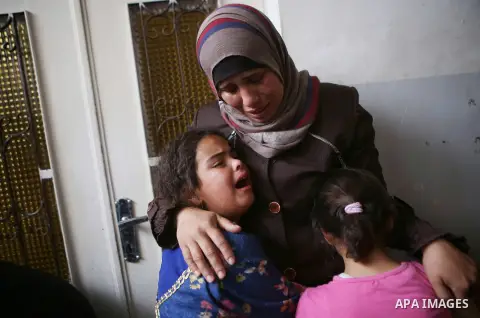 Relatives of 13-year-old Palestinian boy Ahmed Sharaka, who was killed by Israeli troops during clashes on Sunday after being hit in the head by a plastic-coated metal bullet, mourn during his funeral in Jalazoun refugee...
