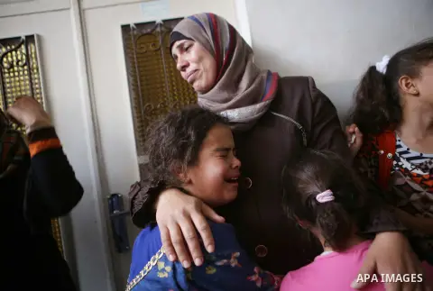 Relatives of 13-year-old Palestinian boy Ahmed Sharaka, who was killed by Israeli troops during clashes on Sunday after being hit in the head by a plastic-coated metal bullet, mourn during his funeral in Jalazoun refugee...