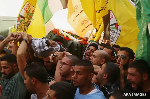 Mourners carry the body of 13-year-old Palestinian boy Ahmed Sharaka, who was killed by Israeli troops during clashes on Sunday after being hit in the head by a plastic-coated metal bullet, during his funeral in Jalazoun...