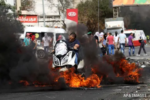 Palestinian protesters hurl stones toward Israeli security forces at the Hawara checkpoint, south of the West Bank city of Nablus, on October 12, 2015. Three new stabbings in Jerusalem and a car attack spread more fear a...