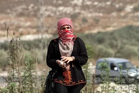 A female Palestinian protester holds stones during clashes with Israeli security forces at the Hawara checkpoint, south of the West Bank city of Nablus, on October 12, 2015. Three new stabbings in Jerusalem and a car att...