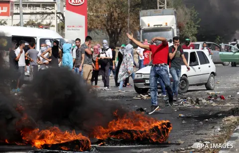 Palestinian protesters hurl stones toward Israeli security forces at the Hawara checkpoint, south of the West Bank city of Nablus, on October 12, 2015. Three new stabbings in Jerusalem and a car attack spread more fear a...