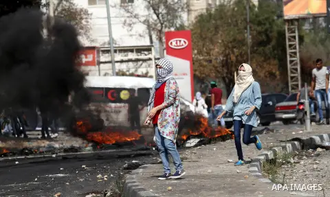 Palestinian protesters hurl stones toward Israeli security forces at the Hawara checkpoint, south of the West Bank city of Nablus, on October 12, 2015. Three new stabbings in Jerusalem and a car attack spread more fear a...
