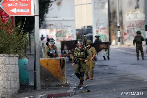 Israeli soldiers aim their weapons towards Palestinian protesters during clashes at the main entrance of the West Bank city of Bethlehem, on October 12, 2015. Frustrated Palestinian youths have defied president Mahmud Ab...