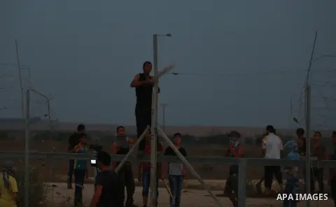 Palestinian protestors gather after tearing down a section of a border fence between Israel and the Gaza Strip during clashes with Israeli security forces on October 12, 2015, east of Bureij in central Gaza. Palestinian...