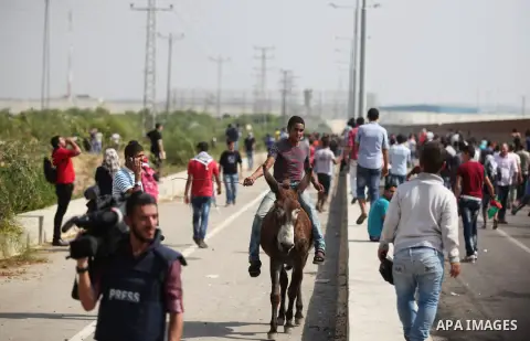 A Palestinian boy rides on a donkey during clashes with Israeli security forces next to the border fence with Israel, at the Erez crossing in the northern Gaza strip, on October 13, 2015. A wave of stabbings that hit Isr...