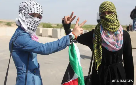 Palestinian girls flash victory sign during clashes with Israeli security forces next to the border fence with Israel, at the Erez crossing in the northern Gaza strip, on October 13, 2015. A wave of stabbings that hit Is...