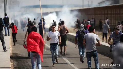 Palestinian protesters clash with Israeli security forces next to the border fence with Israel, at the Erez crossing in the northern Gaza strip, on October 13, 2015. A wave of stabbings that hit Israel, Jerusalem and the...