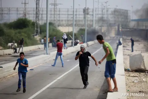 Palestinian protesters clash with Israeli security forces next to the border fence with Israel, at the Erez crossing in the northern Gaza strip, on October 13, 2015. A wave of stabbings that hit Israel, Jerusalem and the...