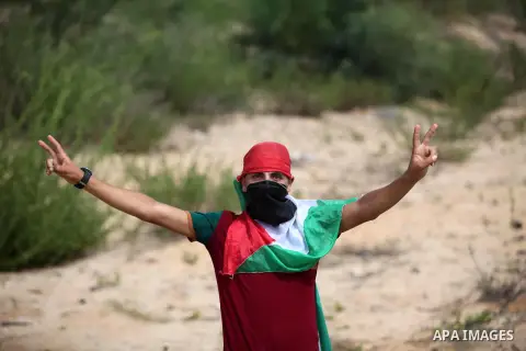 A Palestinian protester flashes victory sign during clashes with Israeli security forces next to the border fence with Israel, at the Erez crossing in the northern Gaza strip, on October 13, 2015. A wave of stabbings tha...